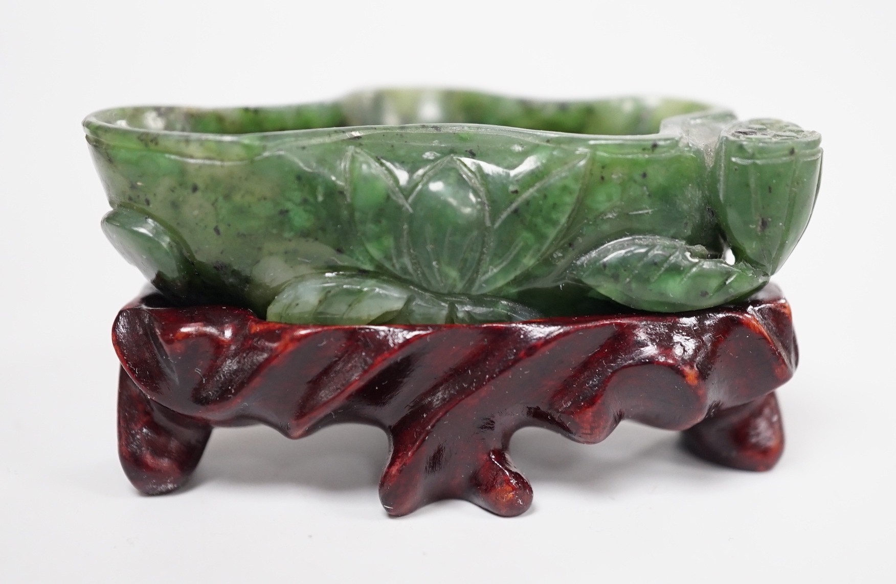 A Chinese spinach green jade 'lotus' brushwasher, 19th century, 6.8cm, wood stand